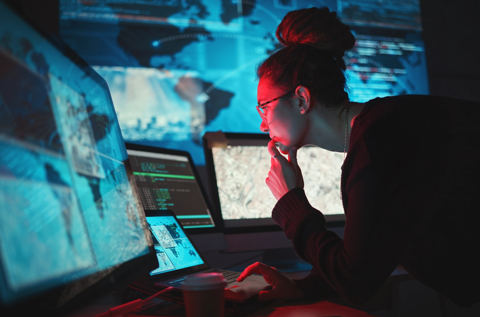 Analista di cybersecurity davanti a un monitor con la rete globale