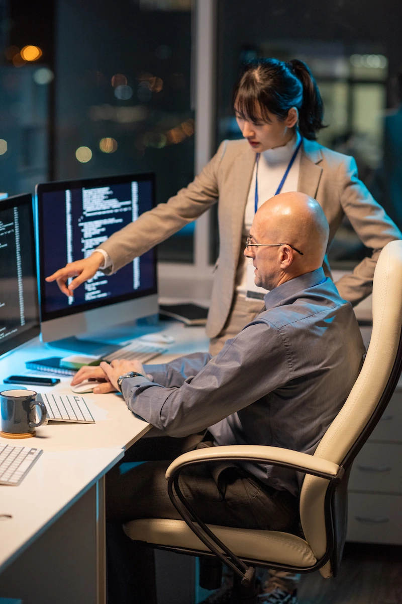 Specialista che mostra dei dati sullo schermo a un collega in ufficio