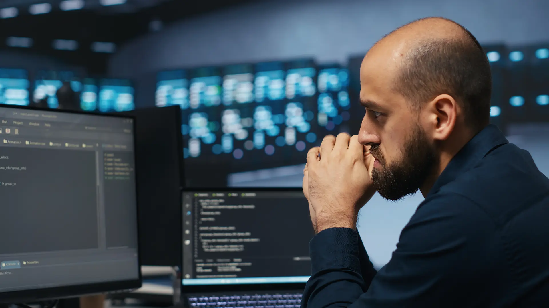 Analista di sicurezza davanti ai monitor di un centro operativo